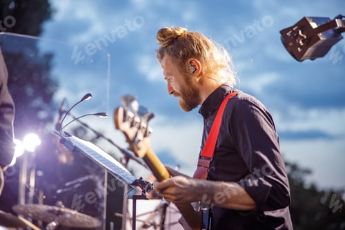 Preview: Musician Playing Bass Guitar on Outdoor Stage