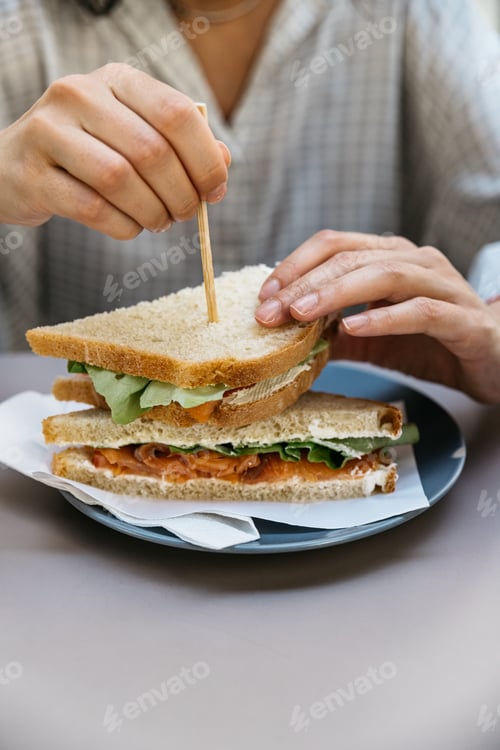 Preview: Woman eating a delicious sandwich for brunch.