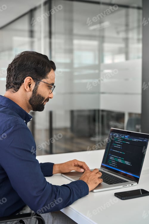 Preview: Indian business man software developer working on laptop in office. Vertical