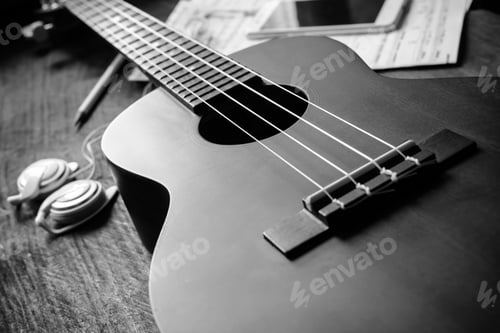 Preview: Ukulele guitar with earphone on wooden table