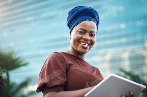 Preview: Shot of a young businesswoman using a digital tablet against a city background
