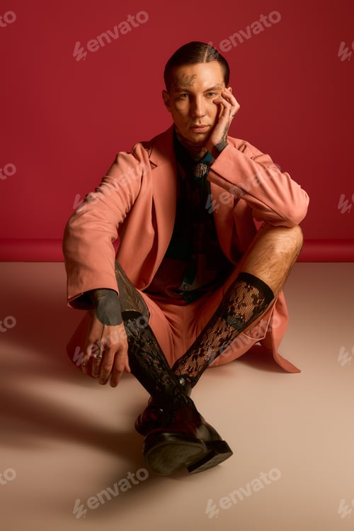 Preview: Charming young man showcases contemporary fashion with flair in vibrant setting