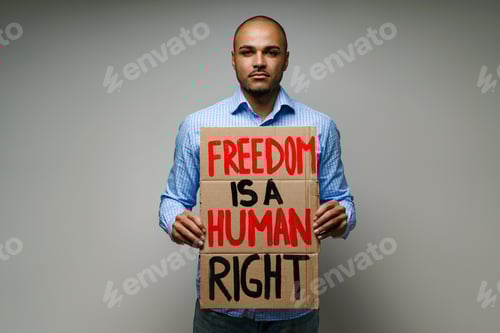 Preview: 'Freedom is a human right' placard in hands of protester man