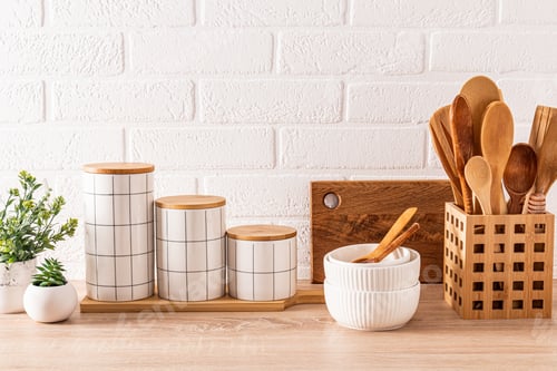 Preview: Beautiful kitchen background with set of cutting boards, wooden spoons, bowls, stylish storage jars.