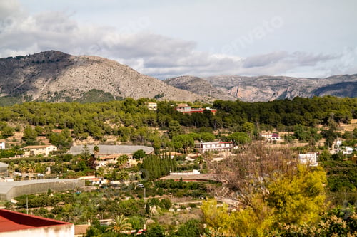 Preview: Bird's eye view of lush nature and buildings of Polop city in Spain with mountains in the background