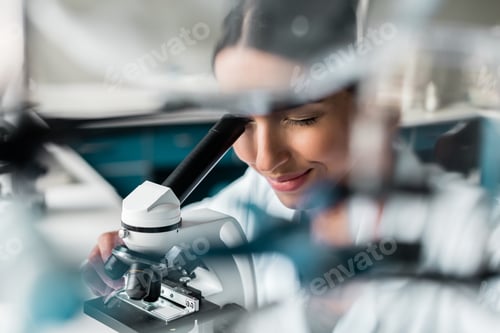 Preview: Professional young scientist working with microscope in chemical lab