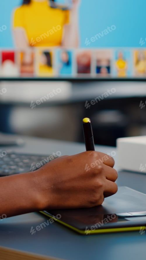 Preview: Close up of african photo retoucher holding stylus pen editing customer photo