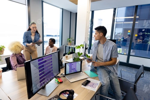 Preview: Diverse colleagues collaborate in modern office business; one shows a tablet, copy space