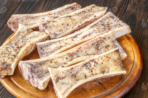 Preview: Rustic roasted marrow bones rest on warm wooden board, savory richness revealed