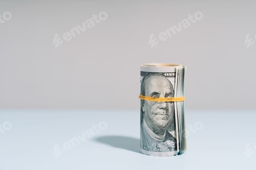 Preview: One hundred dollar bills rolled up on light background