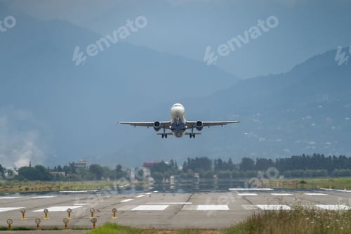 Preview: Airplane taking off from the airport, mountains on background. Transportation concept
