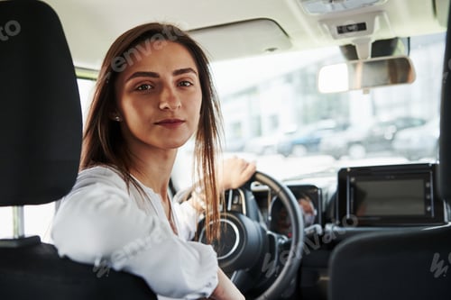 Preview: Cheerful female driver is in her new car. Interior of modern automobile