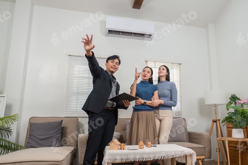 Preview: Real estate agent presenting property options to potential buyers in a modern living room.