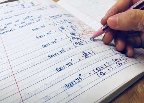 Preview: Closeup people hand doing mathematics homework at home