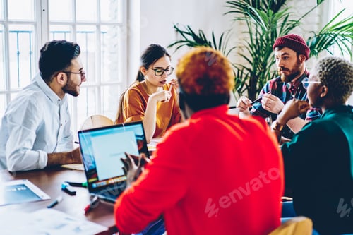 Preview: Group of male and female colleagues sitting at desktop preparing to school exams together,