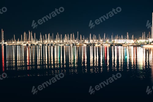 Preview: Yachts and boats in marina of La Spezia at night with reflection in wate
