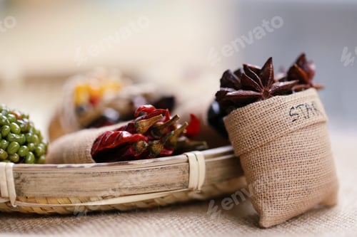 Preview: Food ingredient with dried red chilli, green bean seed in basket and star anise in burlap background