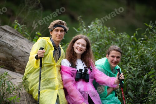 Preview: Group of friends in raincoats with backpacks on a hike in the forest, Prepare to hiking