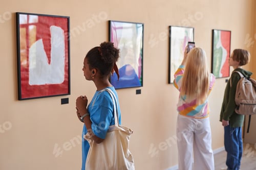 Preview: Diverse group of teenagers looking at abstract art in art gallery