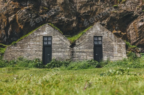 Preview: scenic view of beautiful living houses with grassy roofs under mountain in Iceland