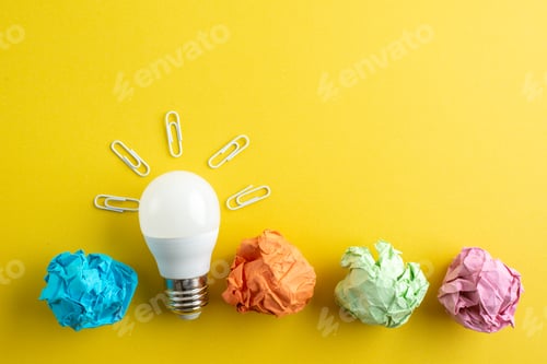 Preview: top view colorful squeezed paper with lightbulb on a yellow background color notepad paper photo