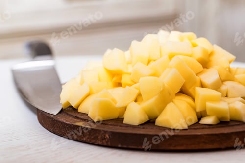 Preview: Pile of potato cut in pieces on wooden board
