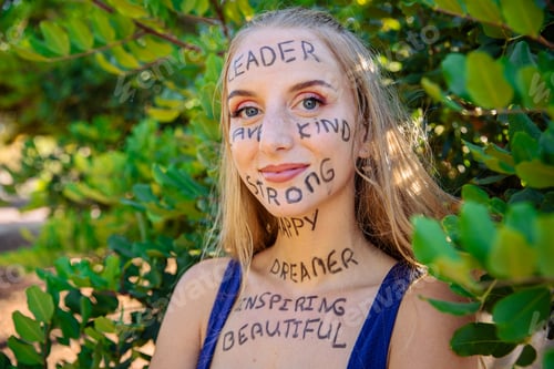 Preview: Portrait of a young woman with motivational words written on her skin, confident woman empowered