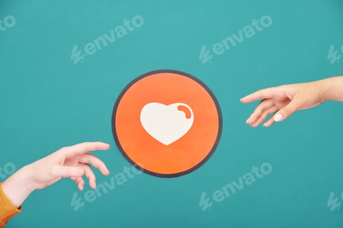 Preview: Hands of young man and woman reaching out for picture of heart in red circle