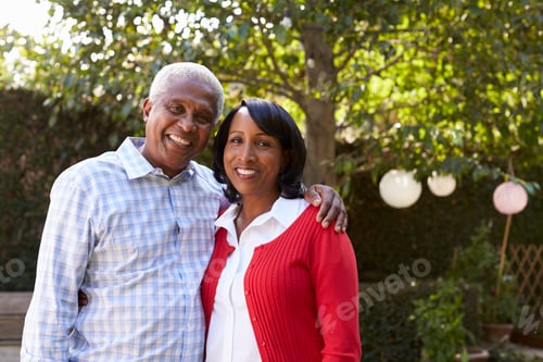 Preview: Senior black couple in their garden looking to camera