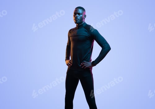 Preview: Confident black sportsman standing on blue background