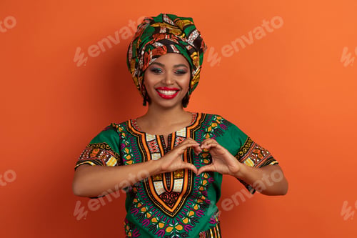 Preview: Positive pretty young black woman showing heart gesture