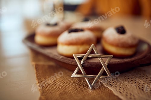 Preview: Close-up of star of David with traditional Jewish jam filled donuts on Hanukkah.