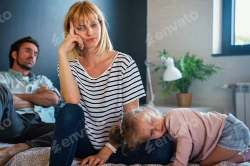Preview: Tired mother and father sitting on couch feels annoyed exhausted stressful with little girl child.