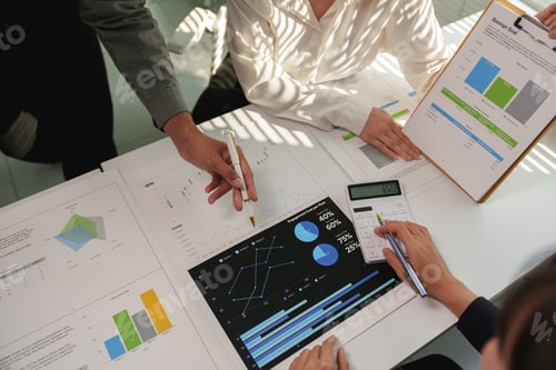 Preview: Business team analyzing financial charts and graphs using a calculator, discussing company's perform