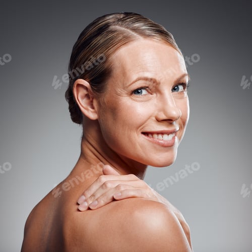 Preview: Beautiful mature woman posing in studio against a grey background