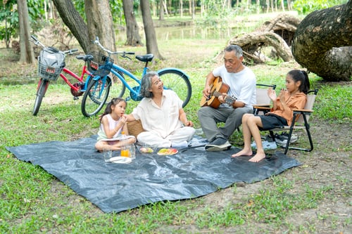 Preview: Side view of Asian grandfather and grandmother enjoy and relax with two girls in public park