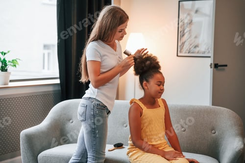 Preview: Mother is combs hair. Young woman with her daughter is together at apartment