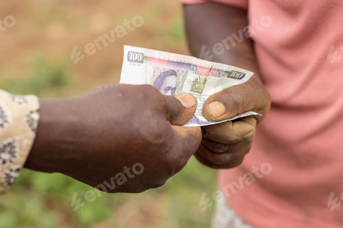 Preview: Farmers (man and woman) exchanging money in Kenyan shilling currency