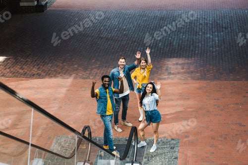 Preview: happy multicultural group of friends gesturing while standing together
