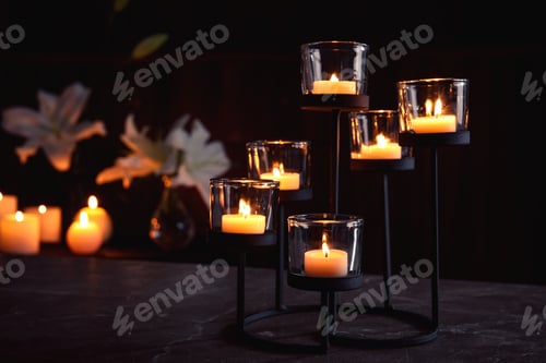 Preview: Holder with burning candles on table in darkness, space for text. Funeral symbol