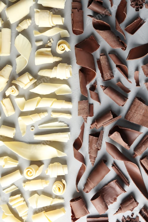 Preview: White and milk chocolate curls on gray background, top view