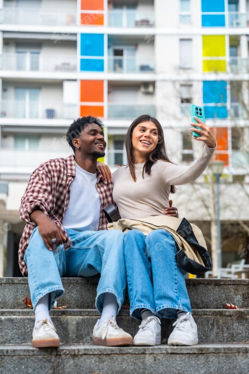 Preview: Diverse young couple taking selfie urban environment
