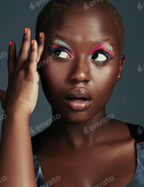 Preview: Cropped shot of a beautiful woman wearing colorful eyeshadow while posing against a grey background