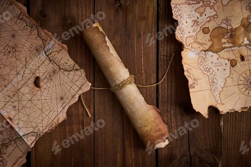 Preview: Antique parchment scroll with old maps on a wooden table.