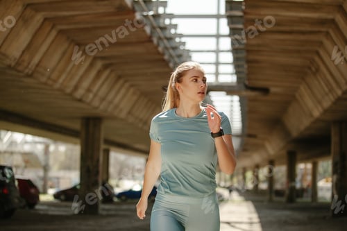 Preview: Close up of beautiful woman running under bridge on the morning.
