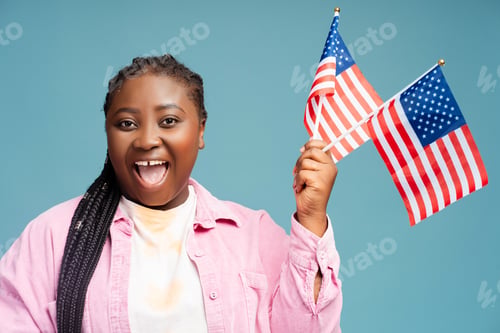 Preview: Beautiful excited plus size African American woman holding American flag looking at camera