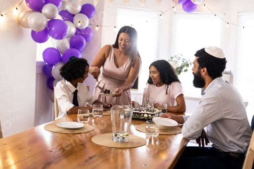 Preview: Family celebrating religious occasion at home, sharing cake and smiling together