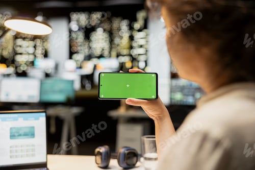Preview: Green screen mockup with woman looking at mobile phone during work session