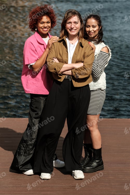 Preview: Multiracial group of female friends smiling in front of camera.