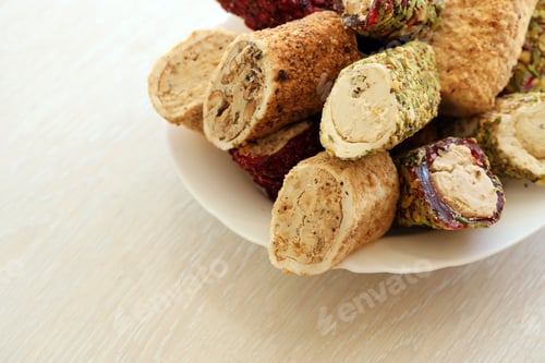 Preview: Many rolls of turkish delight with different flavors and fillings in white plate on table